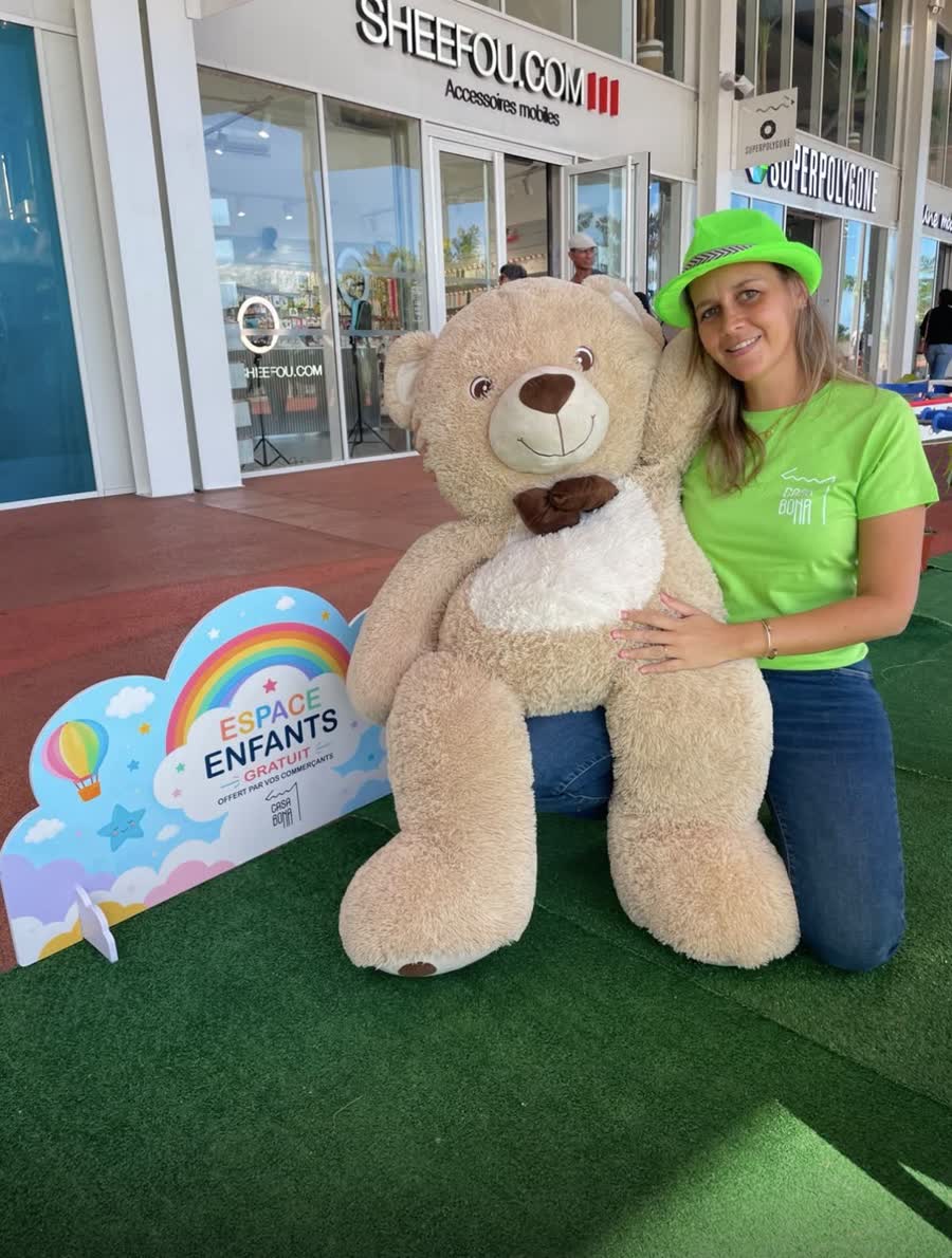 Hôtesse du club enfants avec un ours géant lors d'une animation à La Réunion