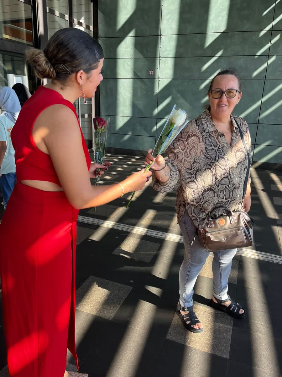 Hôtesse offrant une rose à une cliente pour la fête des mères à La Réunion